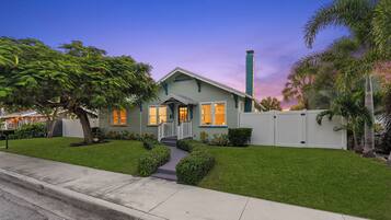 A two-story house with a front porch, a chimney, and a well-maintained lawn.