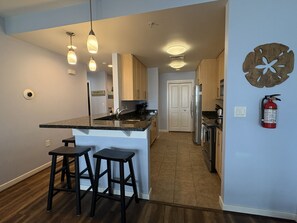 Una cocina moderna con una isla central, taburetes de bar y un refrigerador.