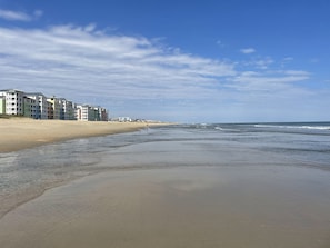 Een strand met gebouwen op de achtergrond.