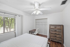 Ein Schlafzimmer mit einem Bett, einem Schreibtisch und einem Kleiderschrank.