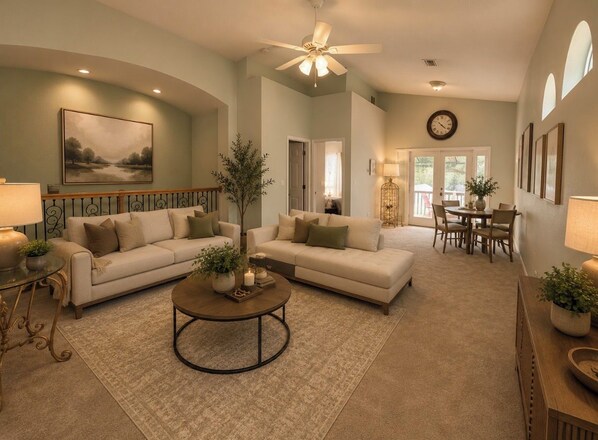 A spacious living room with two sofas, a coffee table, and a dining area with chairs.