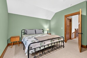 A bedroom with a single bed, a nightstand, a lamp, and a door leading to another room. - Day's End Retreat | Pets, Game Room, Fire Pit & Views in Cheshire Village! (Black Mountain)