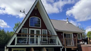 A house with a triangular roof, a balcony, and a chimney.