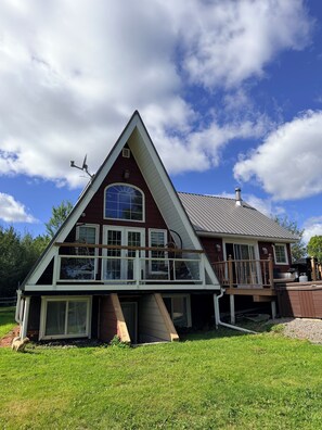 A house with a triangular roof, a balcony, and a chimney.