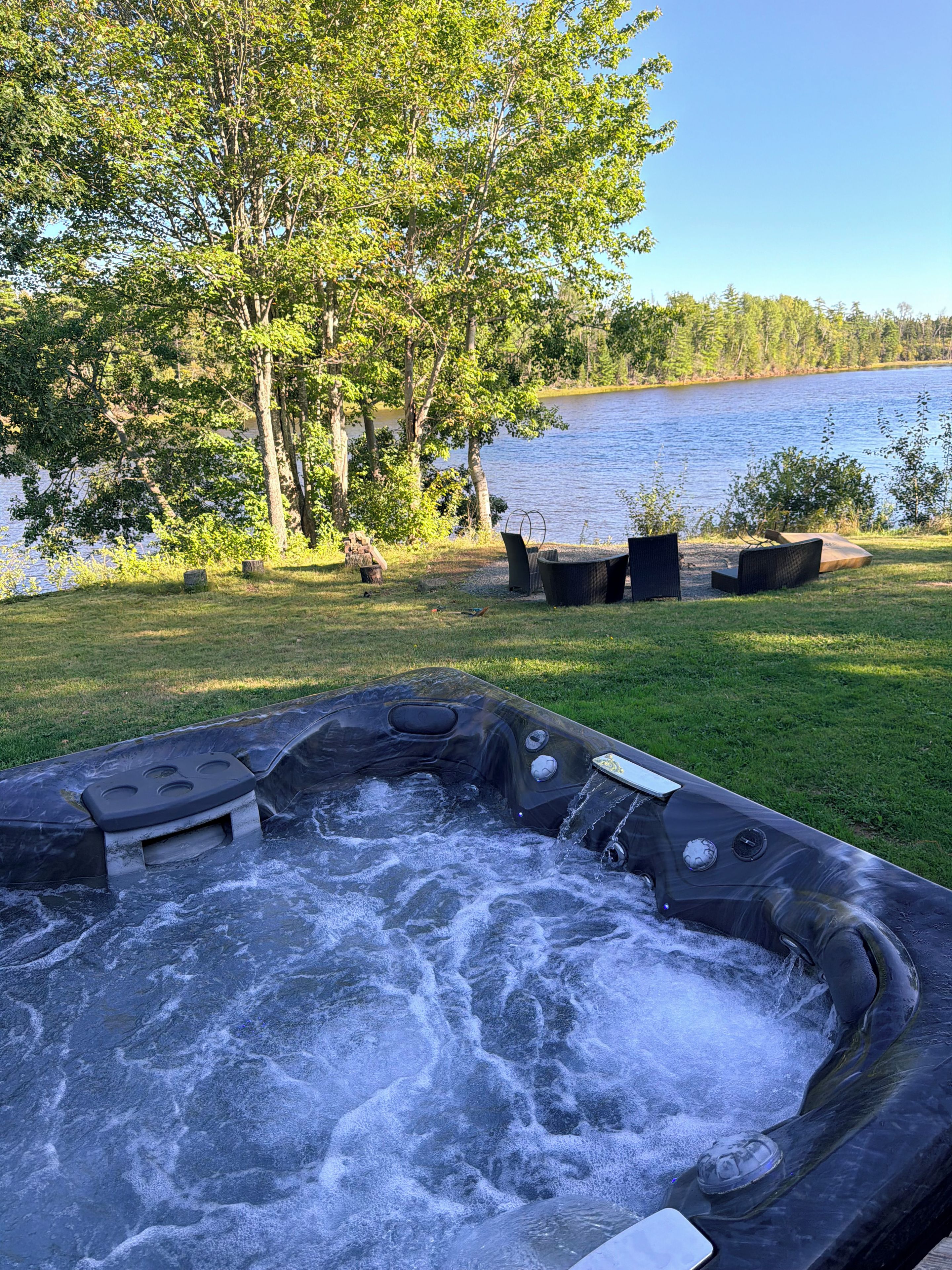 A hot tub with a view of a lake and trees.
