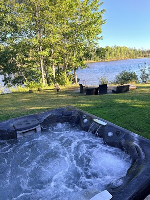 Un jacuzzi con vistas a un lago y árboles.