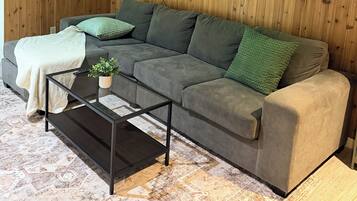 A living room with a grey sofa, a small coffee table, and a framed picture on the wall.