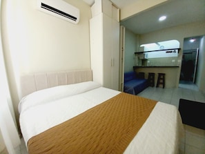 A hotel room with a bed, a kitchenette, and a bathroom. - Cozy in the heart of Leme (Rio de Janeiro)