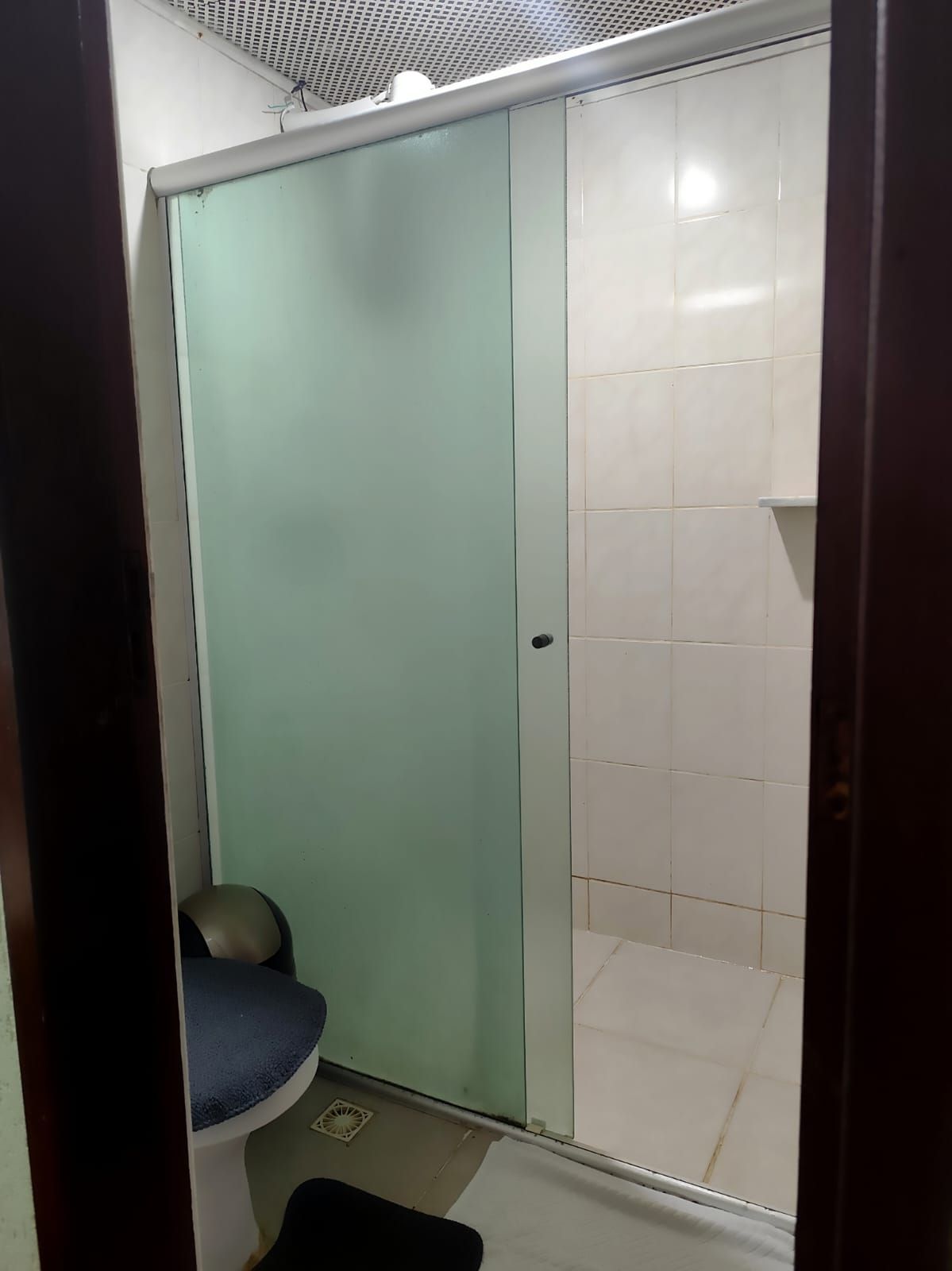 A small bathroom with a shower, a toilet, and a sink.