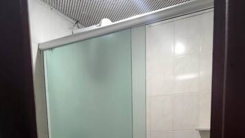 A small bathroom with a shower, a toilet, and a sink.