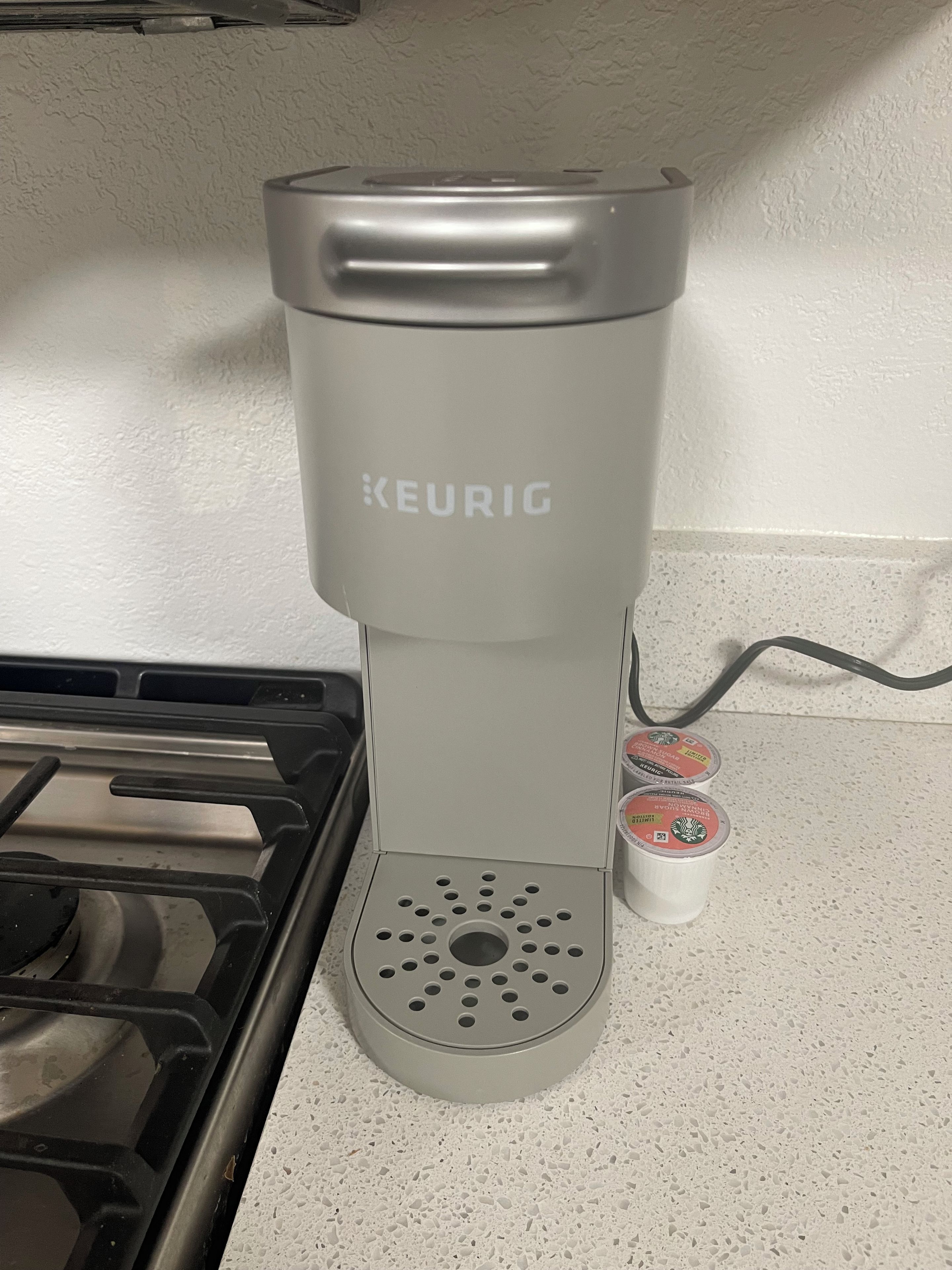 A KEURIG coffee maker with two pods on the counter.