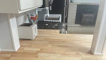 A kitchen with a wooden countertop, two stools, and a stainless steel range hood.