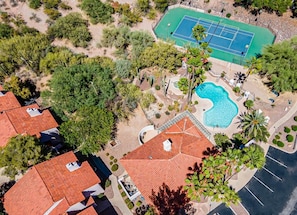 An aerial view of a residential area with a swimming pool, tennis court, and red-roofed houses. - The Hilltop Lookout | Catalina Mountain Views (Tucson)