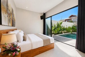 Ein modernes Schlafzimmer mit einem großen Bett, einem Nachttisch mit Lampe und Blick auf einen Swimmingpool.