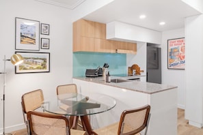 A modern kitchen with a central island, wooden cabinets, and a stainless steel refrigerator. - Funky Teneriffe - 2Bed-2Bath-Balcony-1Car (Teneriffe)