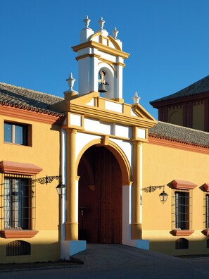 Un edificio con una entrada destacada, una torre de campanas y un tejado de tejas.