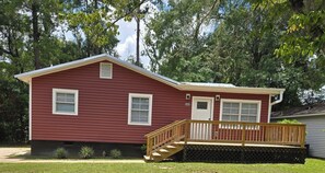 A red single-story house with a front porch, a door, and two windows. - Newly Renovated Tallahassee Retreat Minutes from FAMU, FSU & Downtown (Tallahassee)
