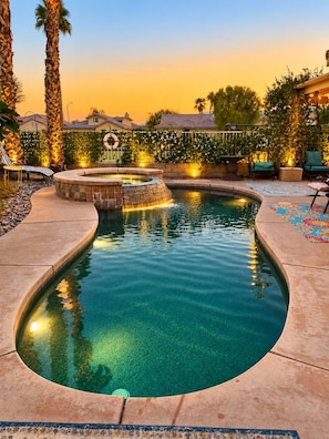 A swimming pool with a hot tub, surrounded by palm trees and a fence with a wreath. - Redford Casita, 1BD/1BA, Across from Empire Polo, King Bed (Indio)