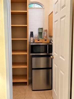 A compact kitchen with a built-in microwave, a coffee maker, and a refrigerator. - Redford Casita, 1BD/1BA, Across from Empire Polo, King Bed (Indio)
