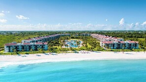 A resort with multiple buildings, a central pool, and a beach. - Luxury Ocean View PH Steps from the Beach (Playa del Carmen)