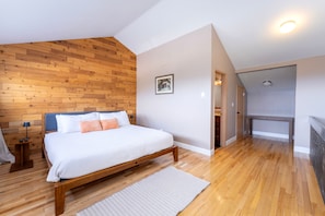 A bedroom with a wooden headboard, a bed with white bedding, a bedside table with a lamp, and a picture on the wall. - New! Ski-In/Ski-Out Condo w/ Mountain Views, Fireplace & Balcony (Whitefish)