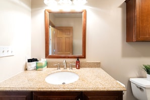 A bathroom with a sink, mirror, and toilet. - New! Ski-In/Ski-Out Condo w/ Mountain Views, Fireplace & Balcony (Whitefish)