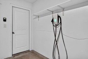 A white door with a lock and a small control panel on the wall to the left.
