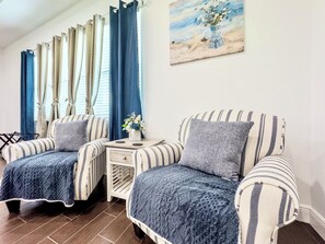 A room with two striped sofas, a small table with a vase, and a painting on the wall. - The Disney Oasis - Your Disney Day! - Your Spa Night! (Kissimmee)