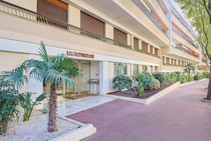 A hotel with a modern facade, a well-maintained entrance, and a landscaped garden area. - Upstays Cosy T2 32m² with balcony and AC (Cannes)