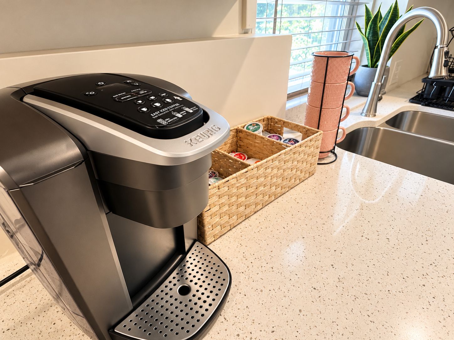 Eine Keurig-Kaffeemaschine auf einer Küchenarbeitsplatte mit einer Kapselvorratsschale.
