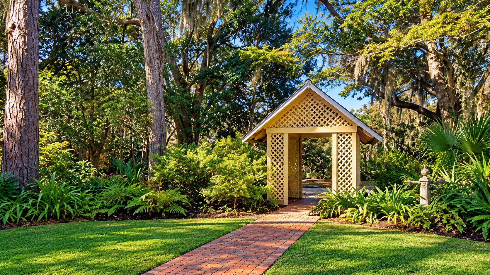 A garden pathway leading to a wooden gazebo with lattice sides.