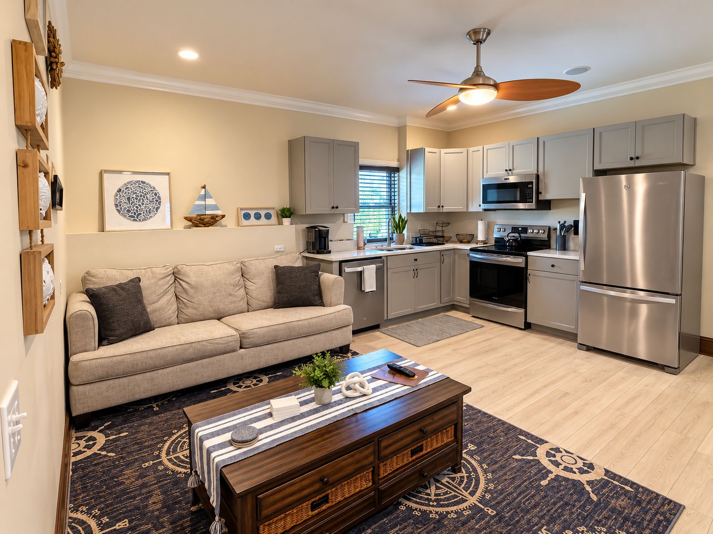 A modern kitchen with stainless steel appliances, a beige sofa, and a wooden coffee table.