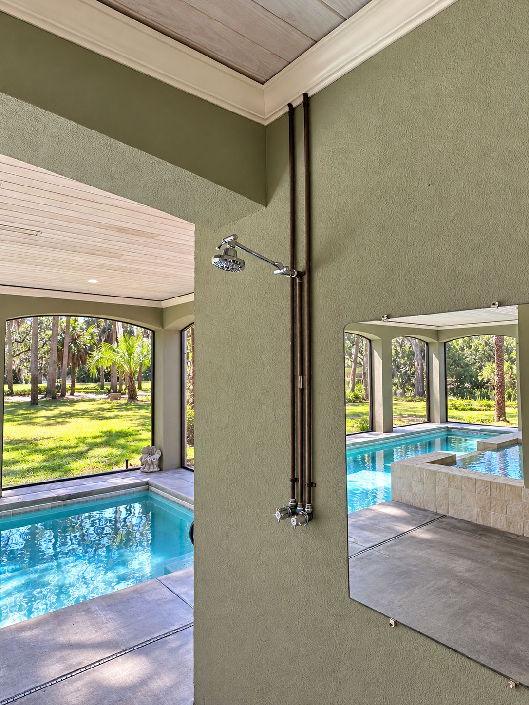 Un baño moderno con un ventanal grande, ducha y zona de piscina.