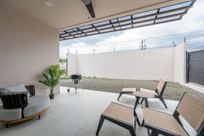 An outdoor patio with a grill, seating, and a view of the sky. - Brisas de Tamarindo | Pool in Front (Tamarindo)