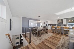 A modern kitchen with white cabinets, a central island, and bar stools. - Unforgettable Ocean Views From Home and Hot Tub, Fire Pit, Chef's Gourmet Kitchen, Steps From Beach (Rockaway Beach)