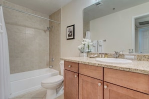 Un baño con bañera, inodoro y lavamanos.