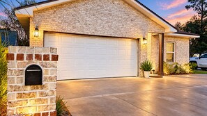 Une maison d’habitation avec un garage, une boîte aux lettres et une plante en pot.
