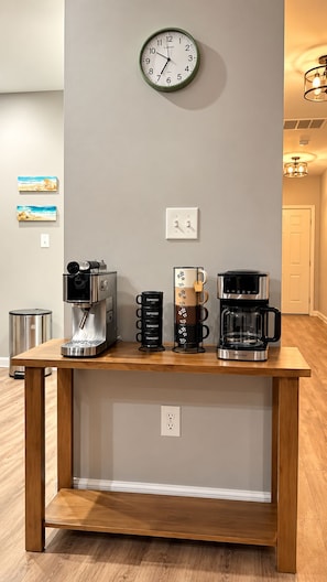 Una estación de café con un reloj de pared, máquinas de espresso y una cafetera.