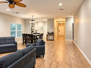A spacious living area with a dining table and chairs, a ceiling fan, and a kitchen area with a coffee machine. - 3-bedroom house in amazing Fort Walton Beach within 6 minutes from the beach. (Fort Walton Beach)