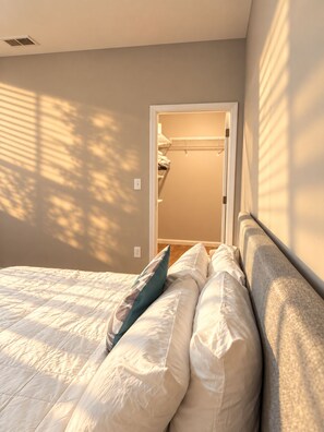 Ein Schlafzimmer mit einem Bett, Kissen und einer Schranktür.