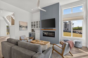 A modern living room with a fireplace, television, and seating area. - 🌊 Palmilla at LBJ | Canal Front Pool, Boat Dock & Hill Country Lake Life 🚤 (Kingsland)
