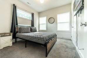 A bedroom with a bed, a bedside table, a wardrobe, and a window. - Charming 4-bedroom house in Charlotte close to Uptown (Charlotte)