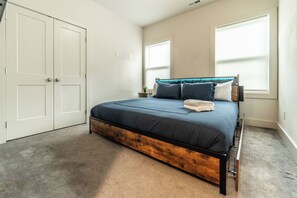 A bedroom with a bed, a wardrobe, and two windows. - Charming 4-bedroom house in Charlotte close to Uptown (Charlotte)