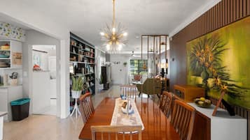 Un espace de salle à manger moderne, avec une table en bois, des chaises et un luminaire au plafond au design original.