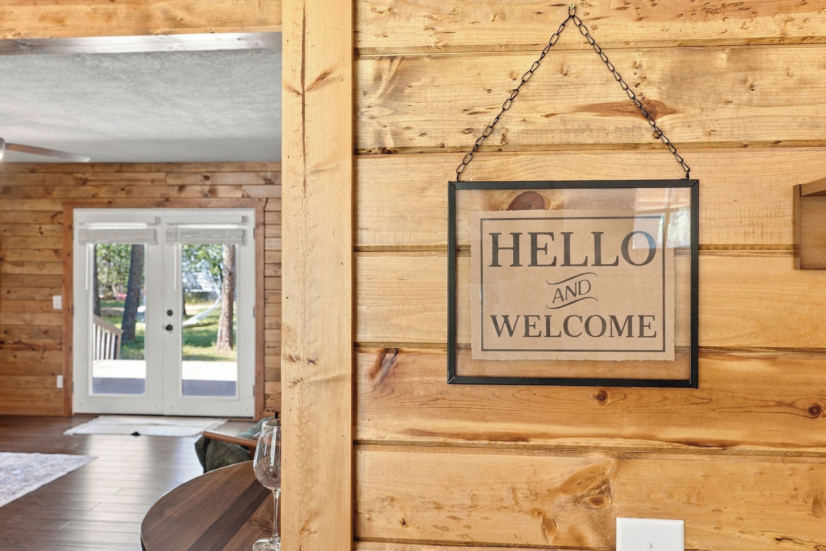 A wooden interior with a framed 'HELLO AND WELCOME' sign.