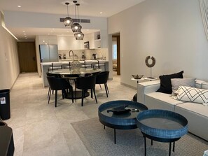 A modern kitchen with a dining area, a sofa, and a coffee table. - Playa Royale 2204 Beachfront apartment with a balcony and ocean view (Nuevo Nayarit)
