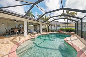 A covered outdoor swimming pool with lounge chairs and a patio area. - The Dock House I Gulf Access I Southern Exposure Pool/Spa (Cape Coral)