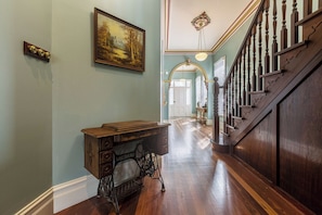 A hallway with a wooden desk, a painting, and a staircase. - VAQUAY The Marigold In Hawthorn (Hawthorn)
