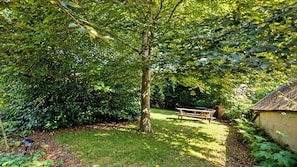 Ein Garten mit Picknicktisch und einer kleinen Gartenhütte.