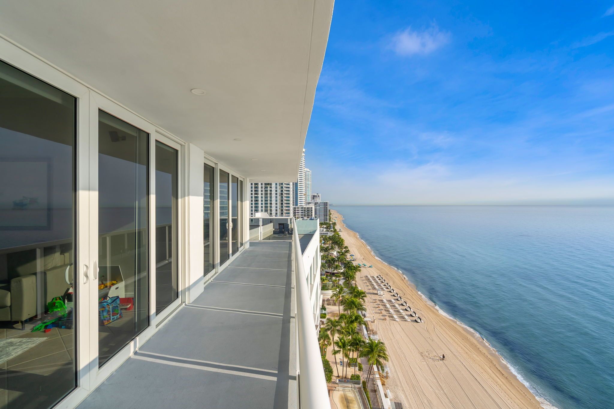 A balcony with a view of a beach and ocean.